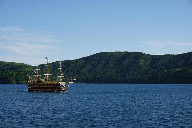Barco de cruzeiro tradicional no Lago Ashi com paisagem montanhosa em Hakone, Japão.