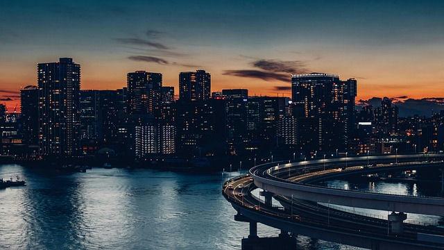 Vista panorâmica da linha de horizonte urbana e edifícios iluminados em Tóquio ao anoitecer.