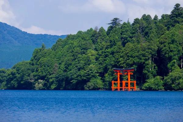 Portal torii vermelho do Santuário Hakone às margens do Lago Ashi