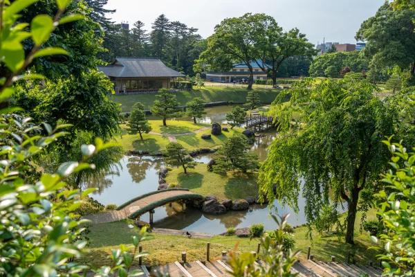 Jardim tradicional japonês com ponte de madeira e lagoa