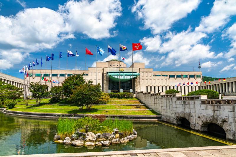 Fachada principal do Memorial de Guerra da Coreia com praça e bandeiras em Seul, Coreia do Sul.